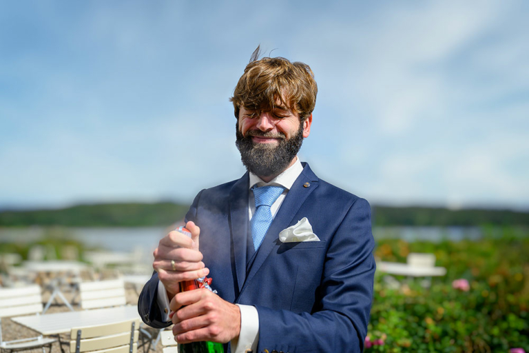 Nach der Trauung im Standesamt von Wassersleben bei Flensburg öffnet der Bräutigam Edwin eine Flasche Sekt.